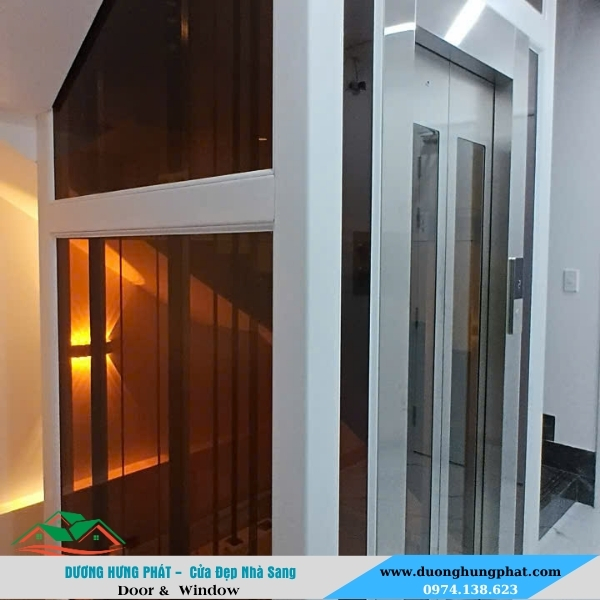 thi công vách kính thang máy màu trà kính cường lực